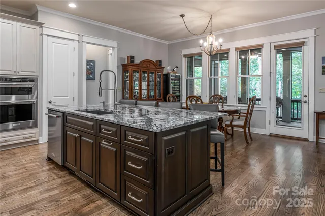 a kitchen with stainless steel appliances granite countertop a stove and a wooden floors