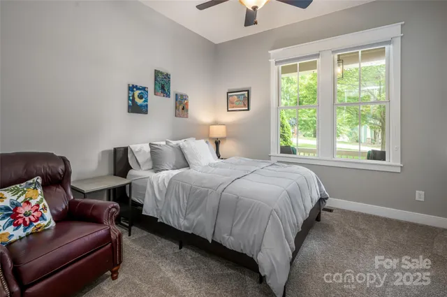 a spacious bedroom with a bed a couch and a window