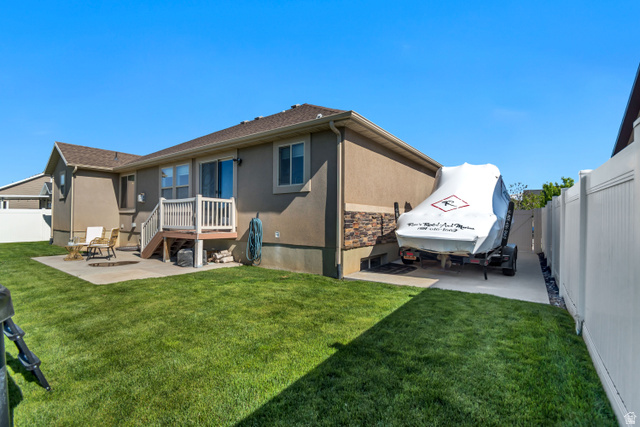 983 West 1550th Street South Springville, UT 84663 - Photo 42 of 43 Expansive backyard featuring a concrete patio, a wooden deck with railing, and a private side yard with a concrete pad.