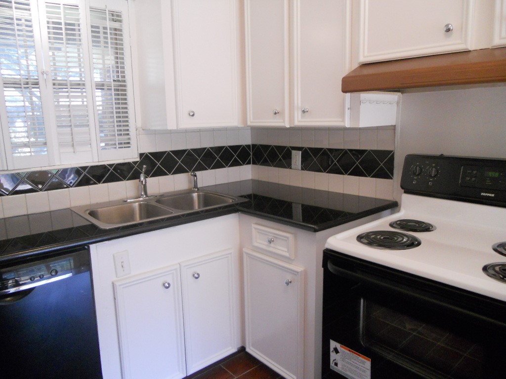 4709 Sanford Road Houston, TX 77035 - Photo 10 of 19 a kitchen that has a sink a stove and cabinets