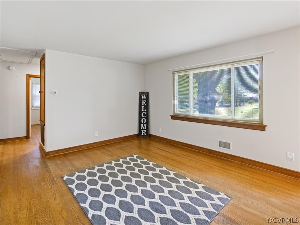 906 Pierpont Road Richmond, VA 23225 - Photo 4 of 24 a view of an empty room with wooden floor and a window