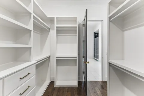 a view of walk in closet with empty racks