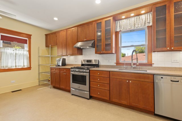 7009 34th Street Berwyn, IL 60402 - Photo 13 of 30 a kitchen with granite countertop a stove a sink and a refrigerator