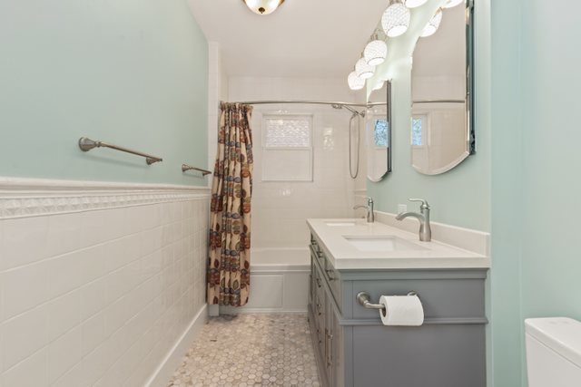 7009 34th Street Berwyn, IL 60402 - Photo 18 of 30 a bathroom with a sink a mirror and a shower