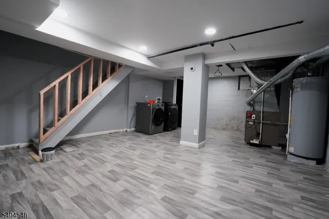a view of an empty room with wooden floor and stairs
