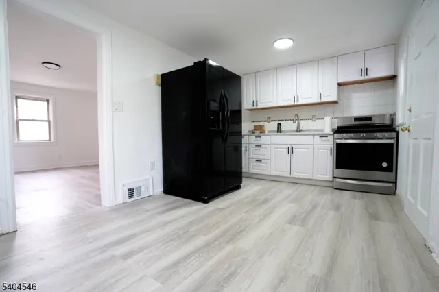 a kitchen with a refrigerator and a stove top oven
