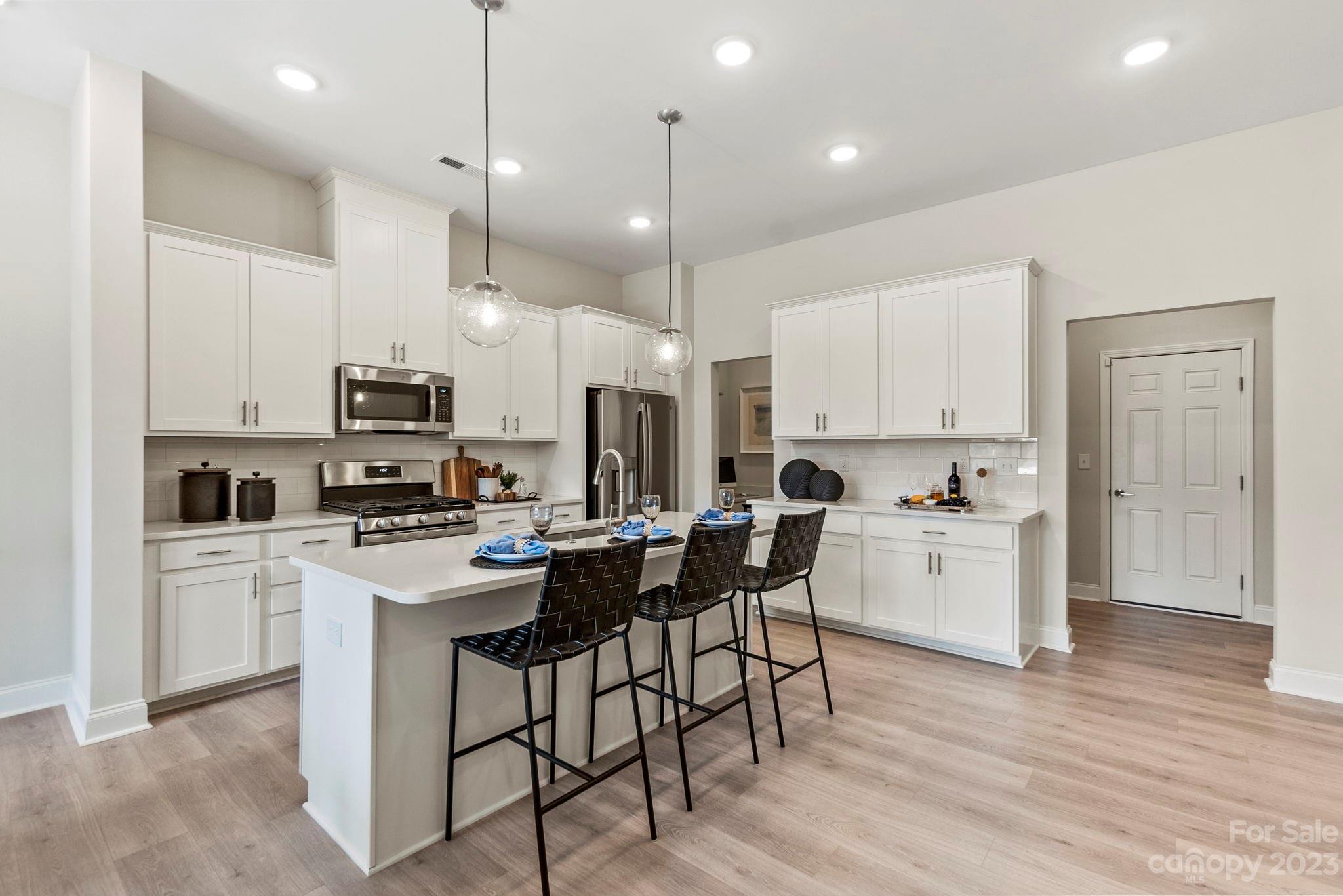 8915 Winding Waters Road Harrisburg, NC 28215 - Photo 12 of 30 a kitchen with white cabinets and white appliances
