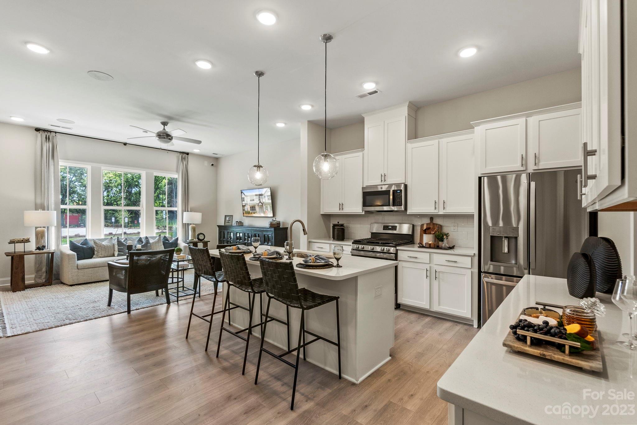 8915 Winding Waters Road Harrisburg, NC 28215 - Photo 14 of 30 a kitchen with stainless steel appliances kitchen island granite countertop a dining table chairs stove a refrigerator and cabinets