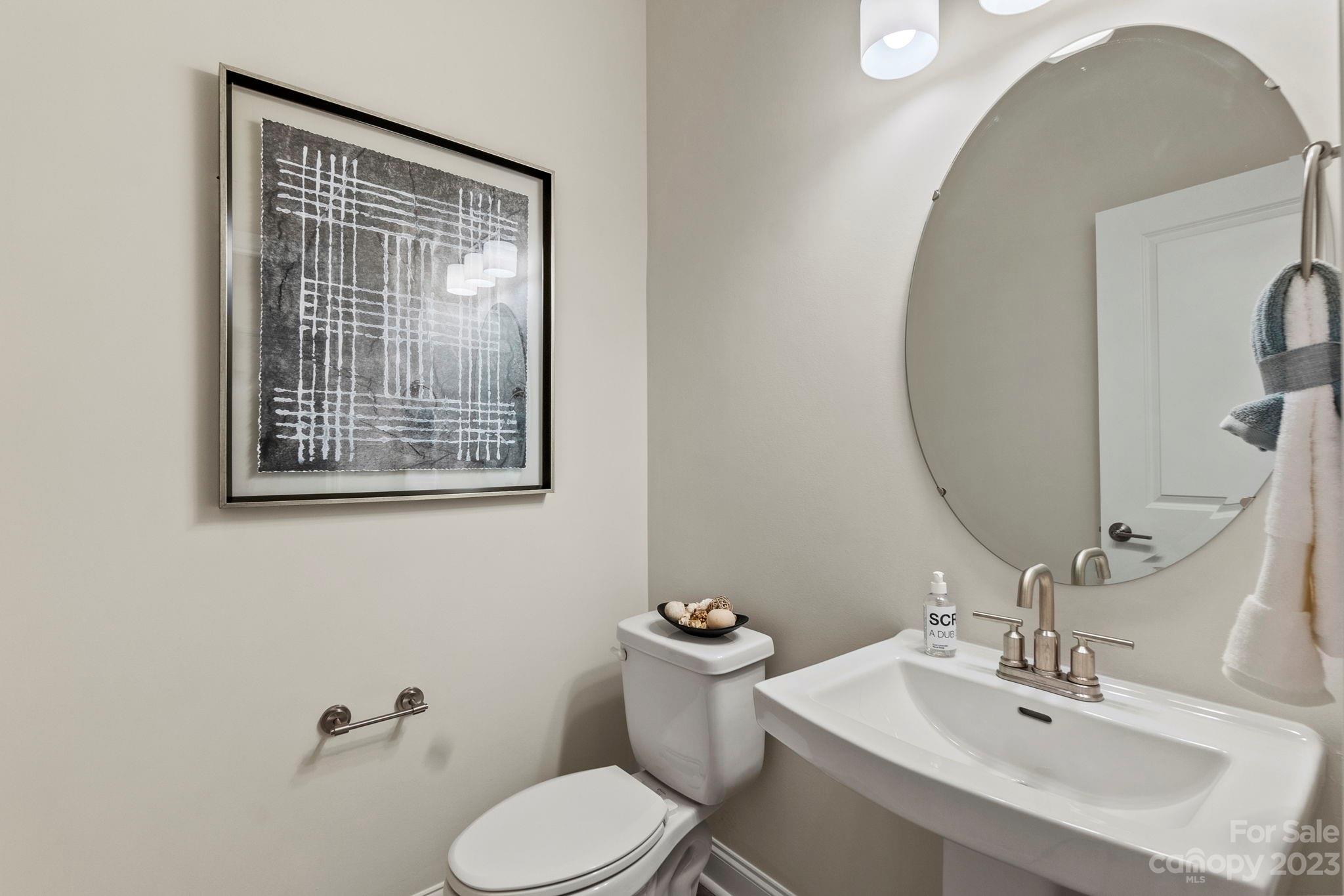 8915 Winding Waters Road Harrisburg, NC 28215 - Photo 16 of 30 a bathroom with a toilet sink and mirror