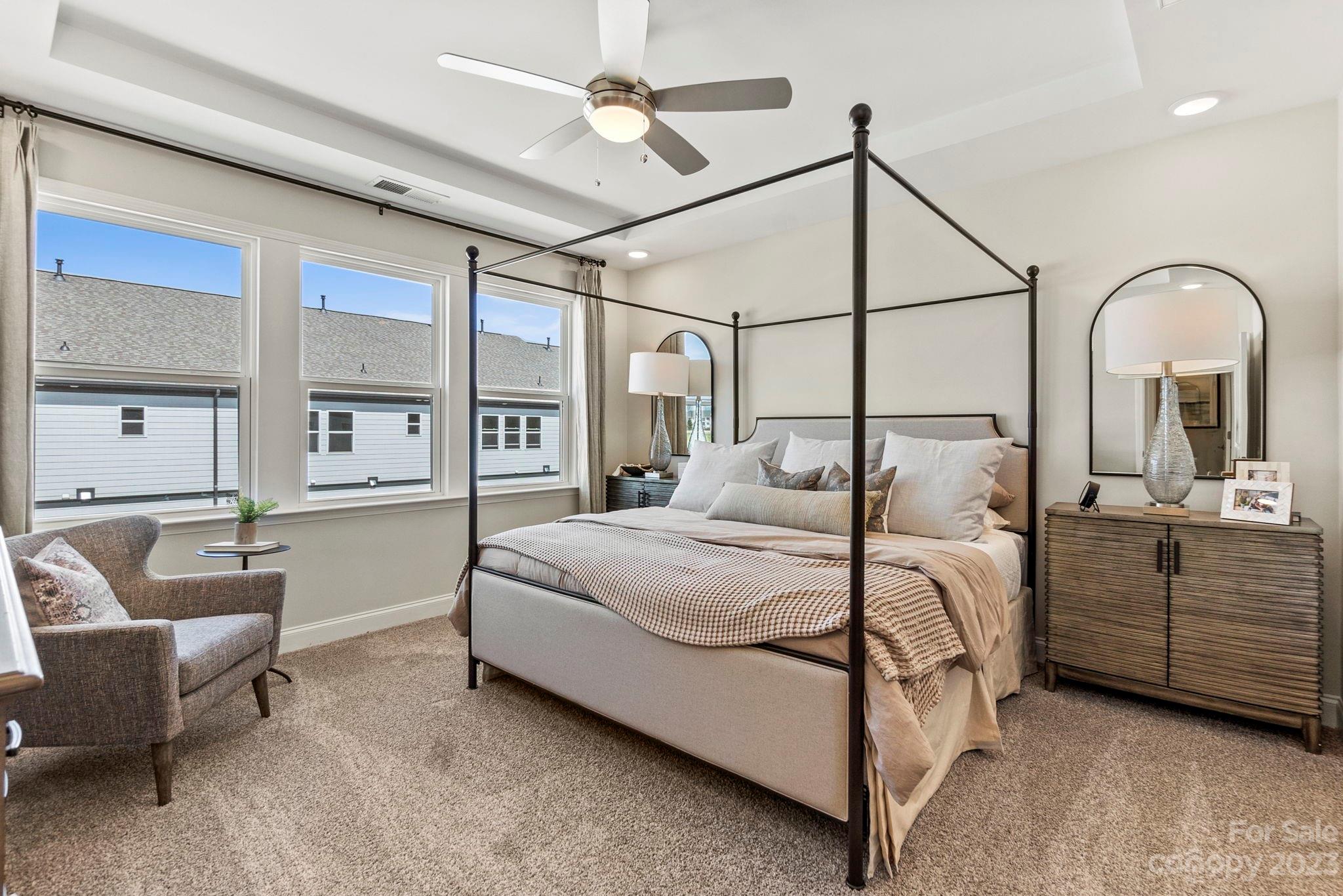 8915 Winding Waters Road Harrisburg, NC 28215 - Photo 19 of 30 a bedroom with a large bed and a chandelier