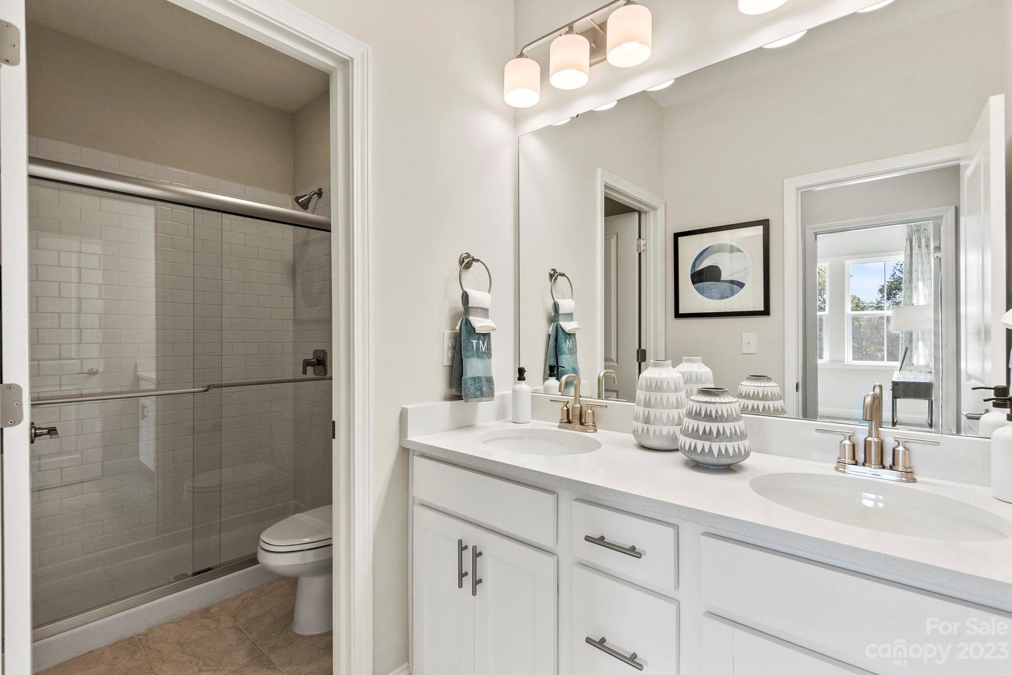 8915 Winding Waters Road Harrisburg, NC 28215 - Photo 26 of 30 a bathroom with a sink a toilet and shower