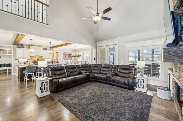 a view of a dining room and livingroom with furniture a chandelier and wooden floor