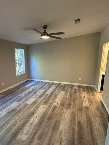 wooden floor in an empty room with a window