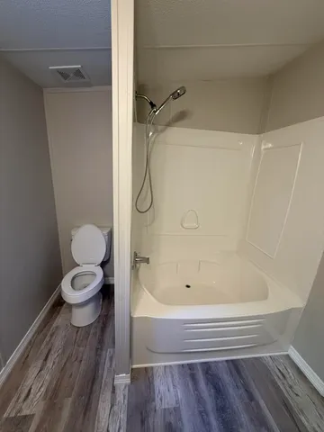 a bathroom with a granite countertop toilet a sink and a shower