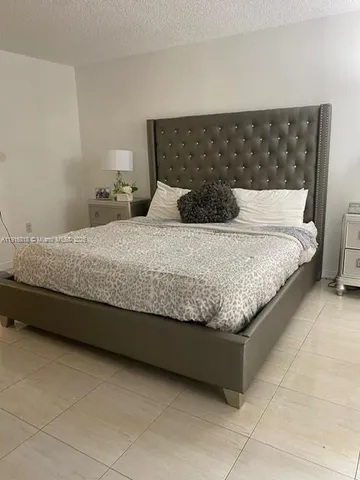 a bedroom with a bed and a mirror on dresser