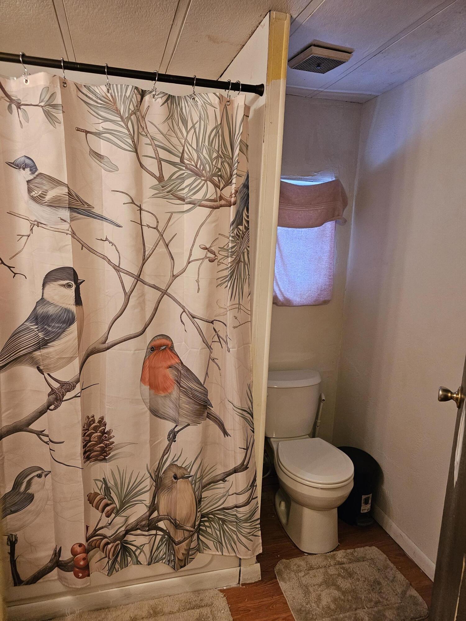 16919 Covina Road Bend, OR 97707 - Photo 7 of 9 a white toilet sitting next to a shower curtain