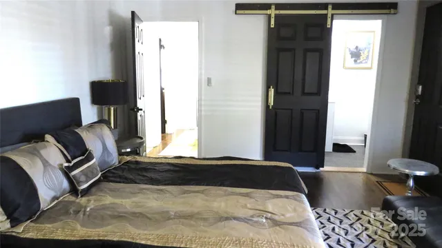 a spacious bedroom with a bed and a flat screen tv