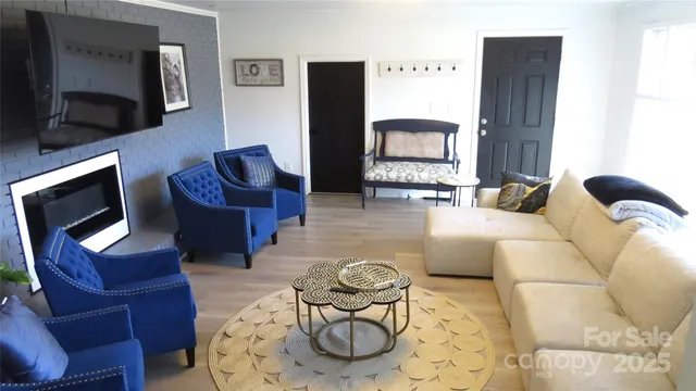 a living room with furniture a flat screen tv and a fireplace