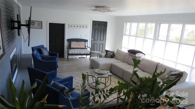 a living room with furniture fireplace and a large window