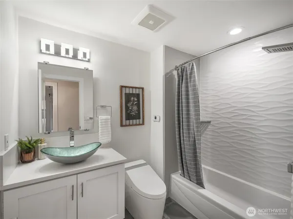 a bathroom with a sink a toilet and shower