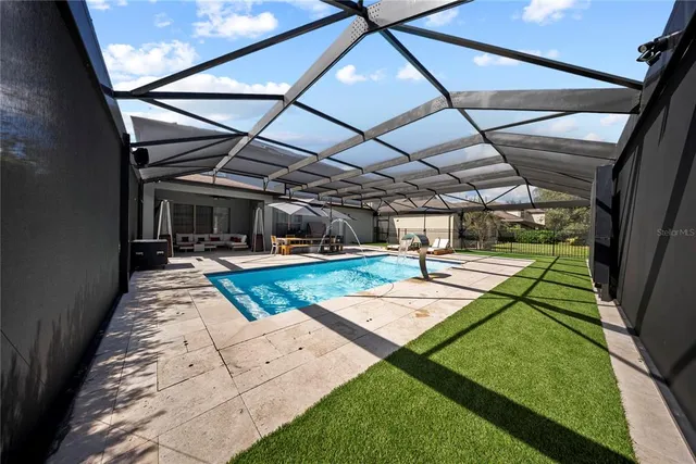 a view of backyard with swimming pool and patio