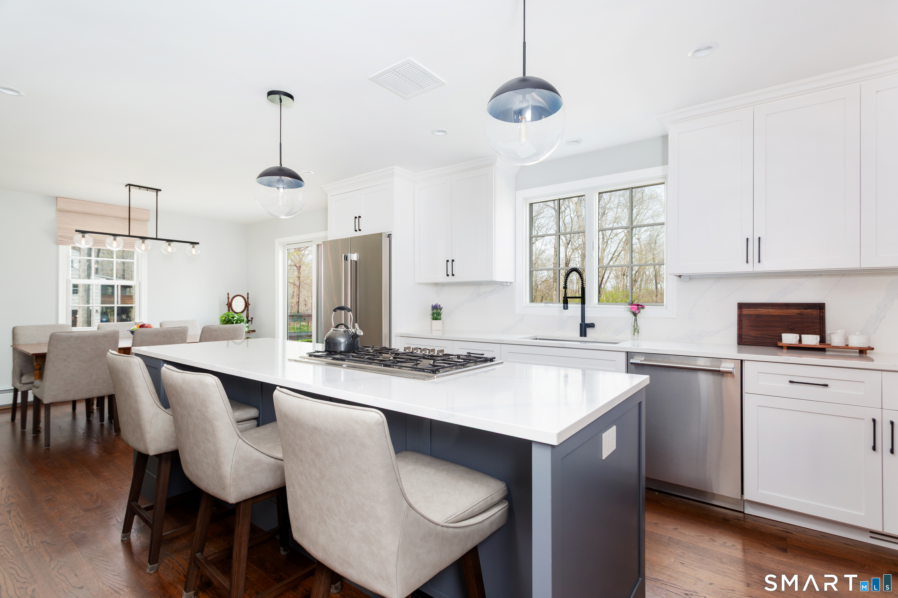 33 Cardinal Road Weston, CT 06883 - Photo 12 of 38 a kitchen with a dining table chairs sink and cabinets