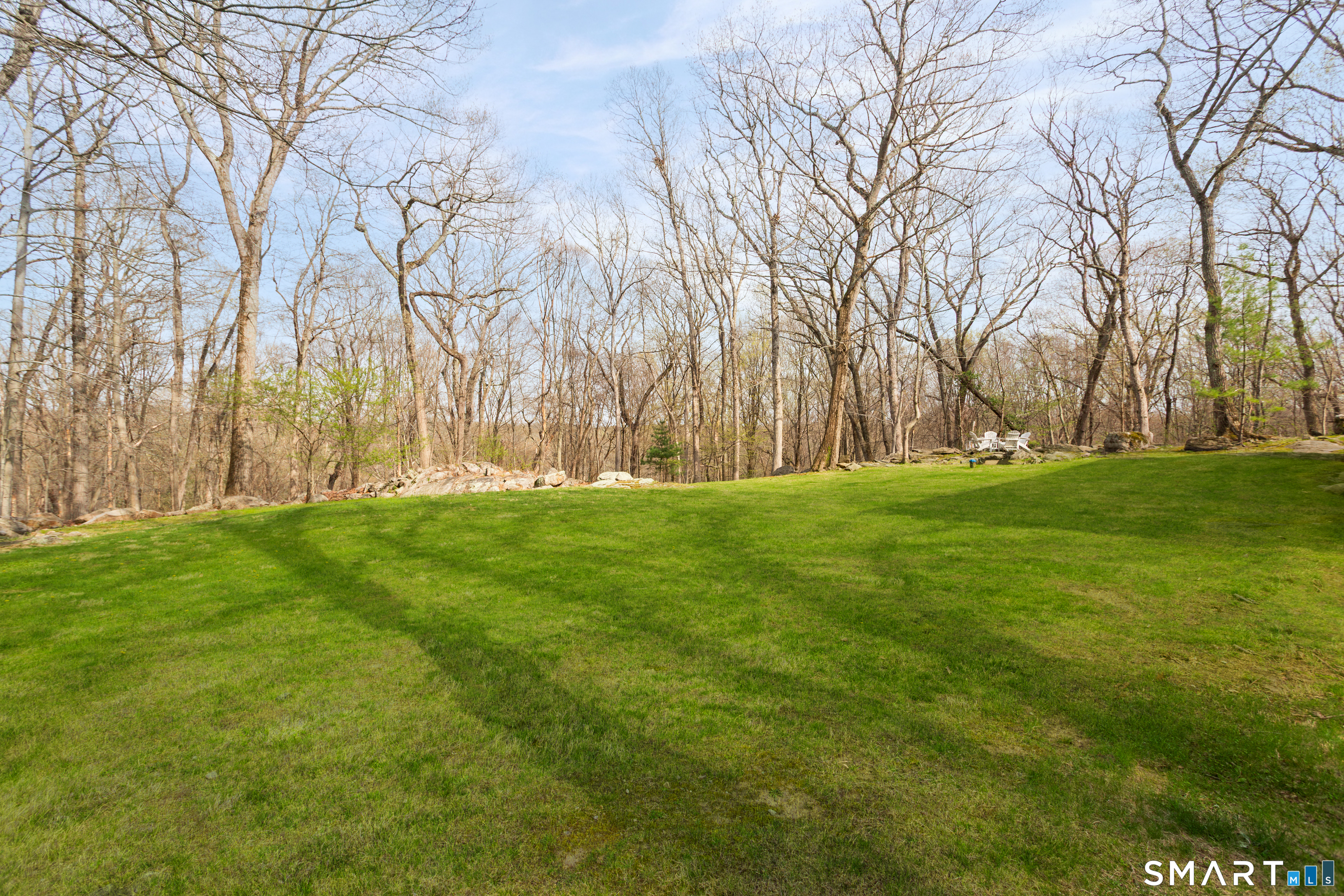 33 Cardinal Road Weston, CT 06883 - Photo 33 of 38 a backyard of apartments with large trees