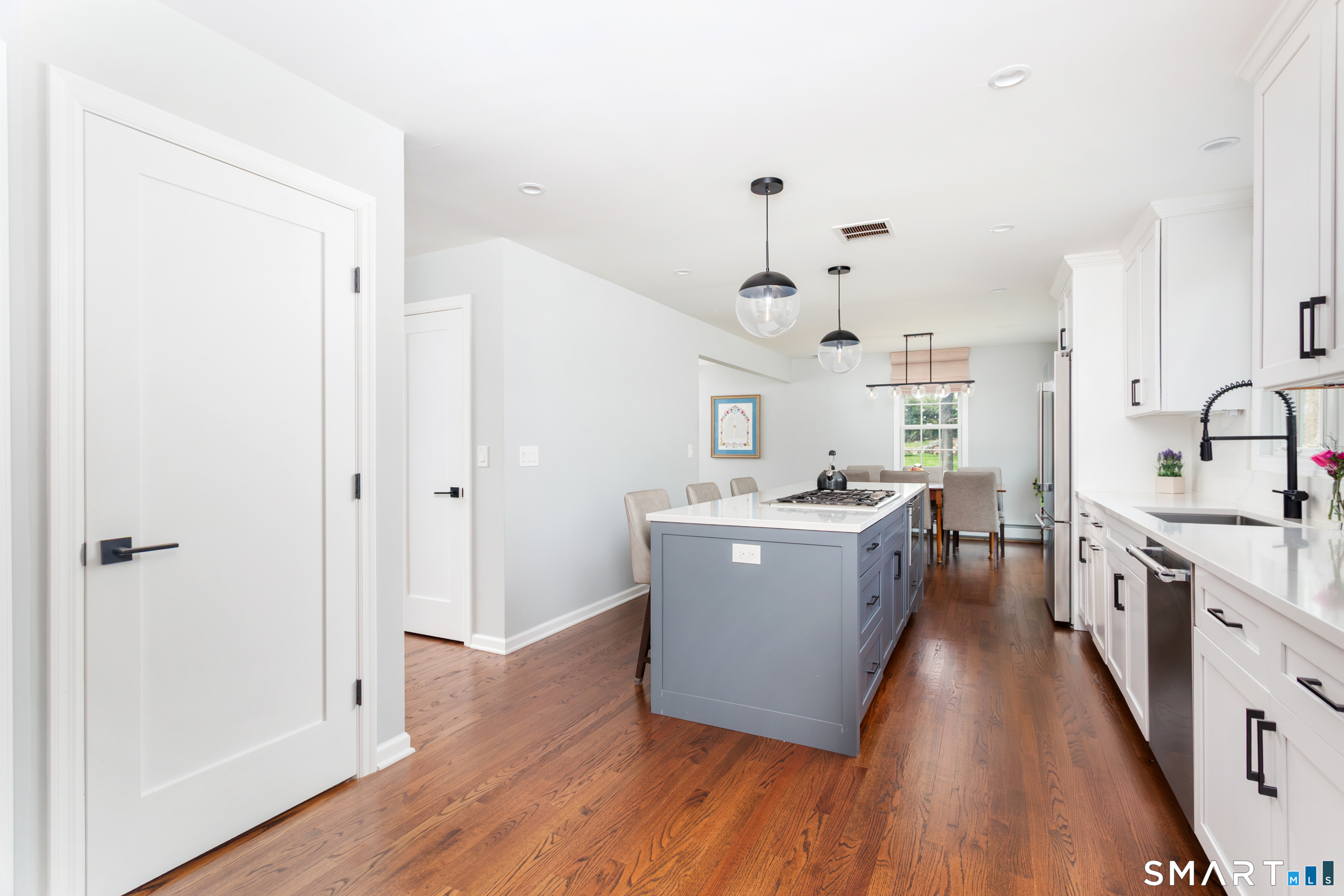33 Cardinal Road Weston, CT 06883 - Photo 10 of 38 a large white kitchen with wooden floor