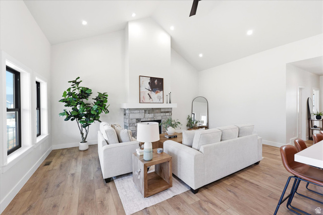 134 South Chamberlain Street Mapleton, UT 84664 - Photo 13 of 40 Spacious living area featuring a vaulted ceiling, wood-finish flooring, a stone-clad fireplace, and recessed lighting