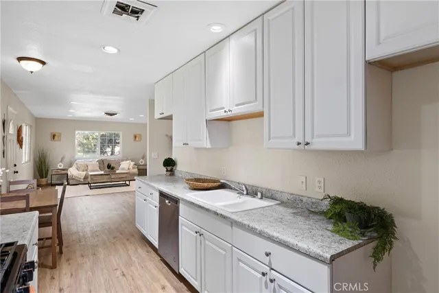 a kitchen with granite countertop a sink stove and cabinets