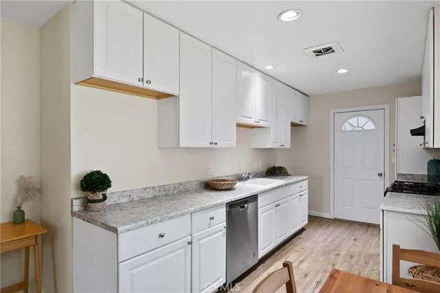 a kitchen with granite countertop cabinets stainless steel appliances and a counter space