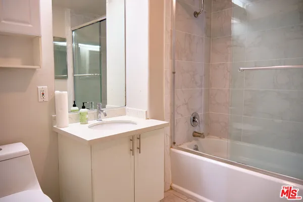 a bathroom with a bathtub shower sink vanity and toilet