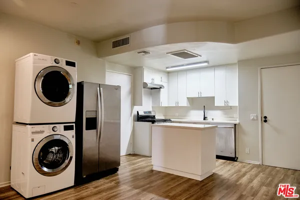 a kitchen with stainless steel appliances granite countertop a sink a stove a refrigerator and cabinets