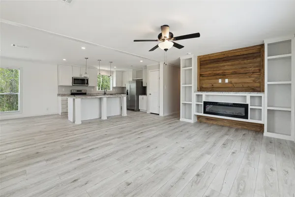a view of a kitchen with wooden floor and a ceiling fan