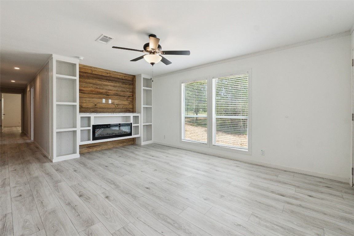855 Roosevelt Road Kingsbury, TX 78638 - Photo 15 of 33 an empty room with wooden floor ceiling fan and windows