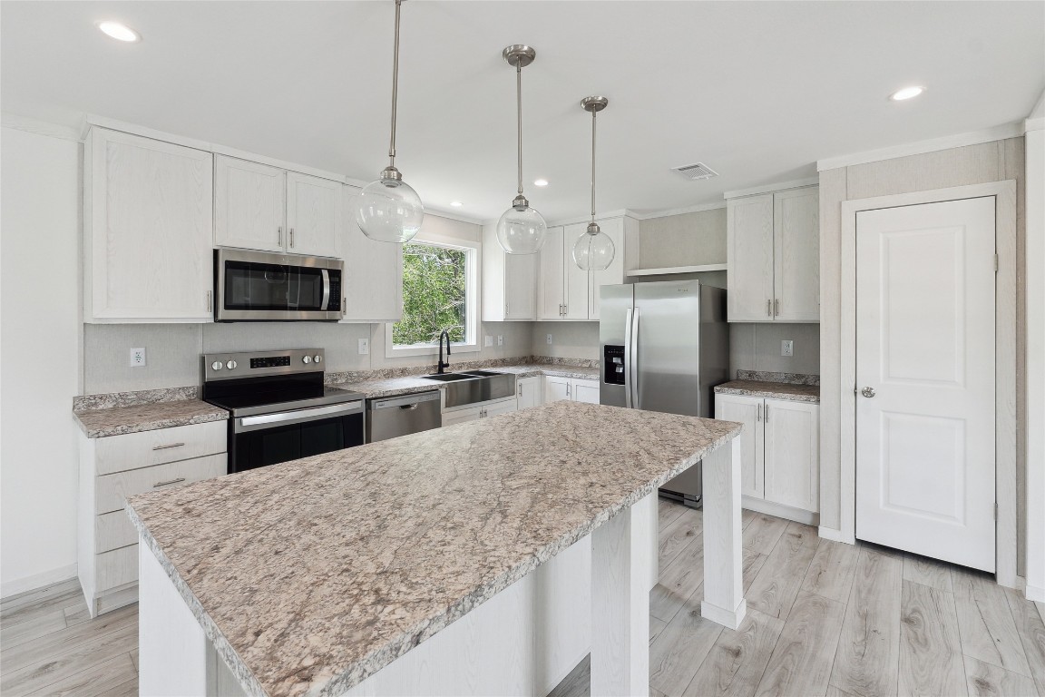 855 Roosevelt Road Kingsbury, TX 78638 - Photo 18 of 33 a kitchen with stainless steel appliances granite countertop a stove refrigerator and a microwave oven
