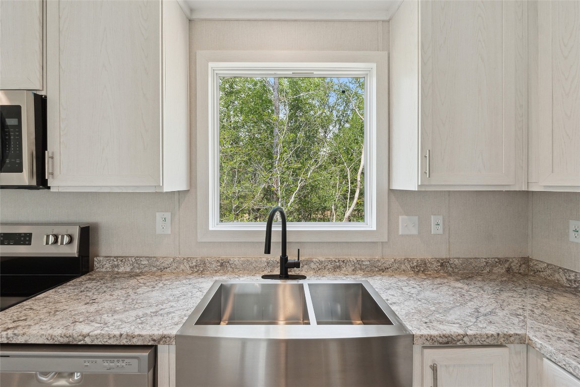 855 Roosevelt Road Kingsbury, TX 78638 - Photo 20 of 33 a kitchen with granite countertop a sink and a window