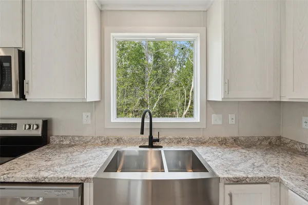 a kitchen with granite countertop a sink and a window