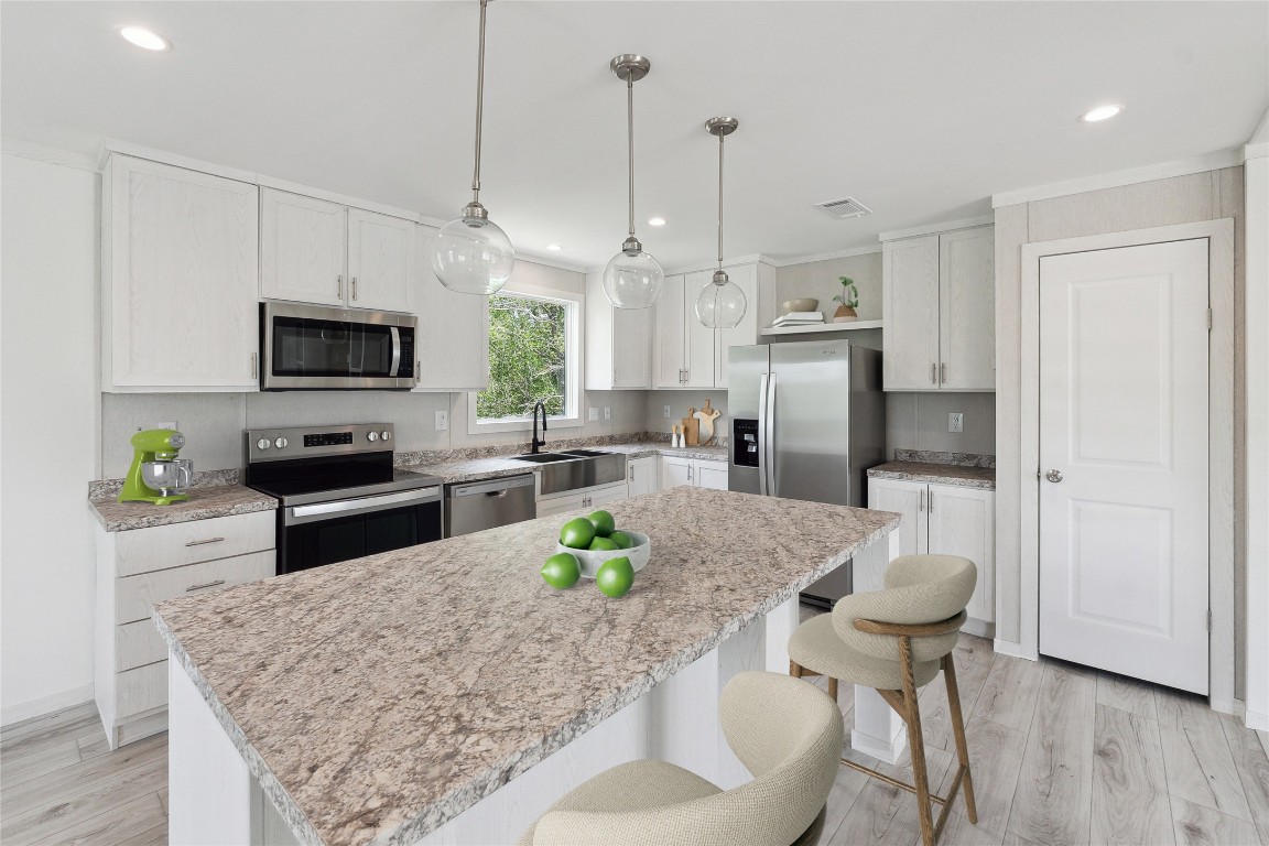 855 Roosevelt Road Kingsbury, TX 78638 - Photo 2 of 33 a kitchen with stainless steel appliances granite countertop a stove a refrigerator a oven a sink a dining table and chairs