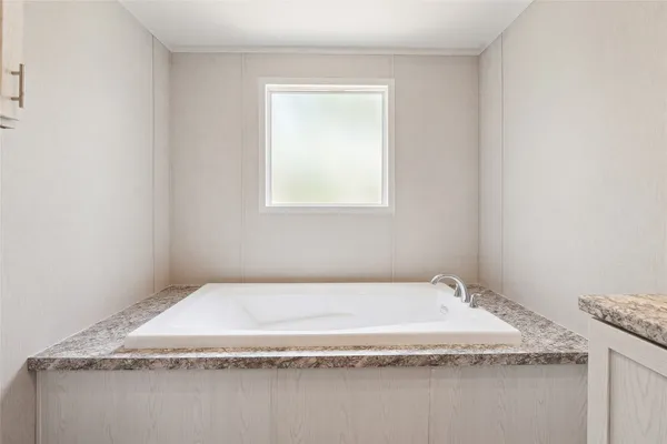 a bathroom with a granite countertop sink and tub