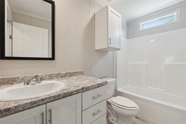 a bathroom with a granite countertop sink a toilet and a bathtub