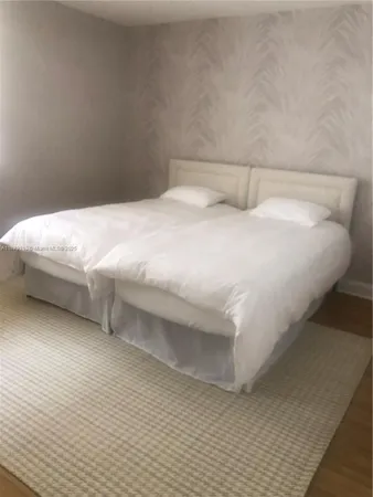 a bedroom with a bed and a white wall