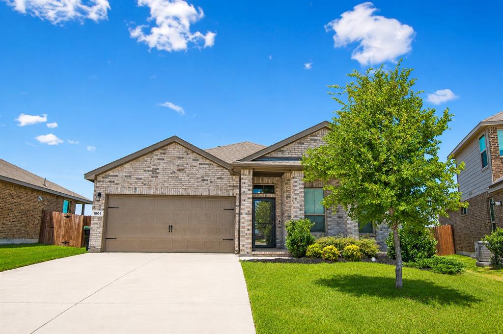 1804 Mensa Drive Haslet, TX 76052 - Photo 30 of 30 Single-story brick exterior featuring an attached two-car garage, concrete driveway, and established front landscaping