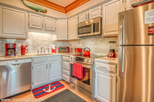 a kitchen with stainless steel appliances granite countertop a refrigerator and a stove