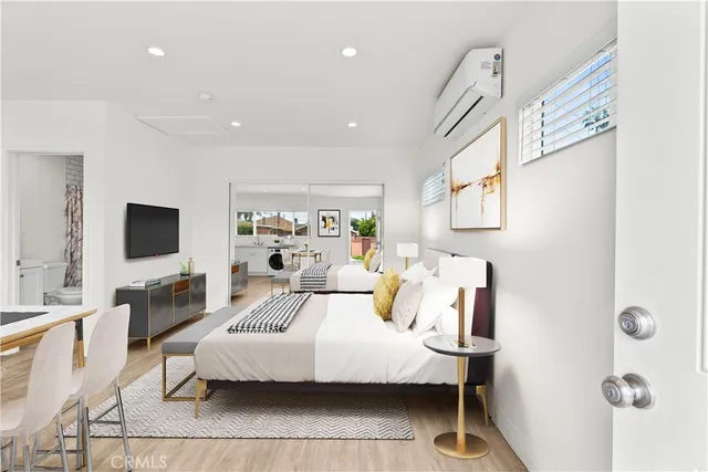 a bedroom with a bed a couch and a flat screen tv