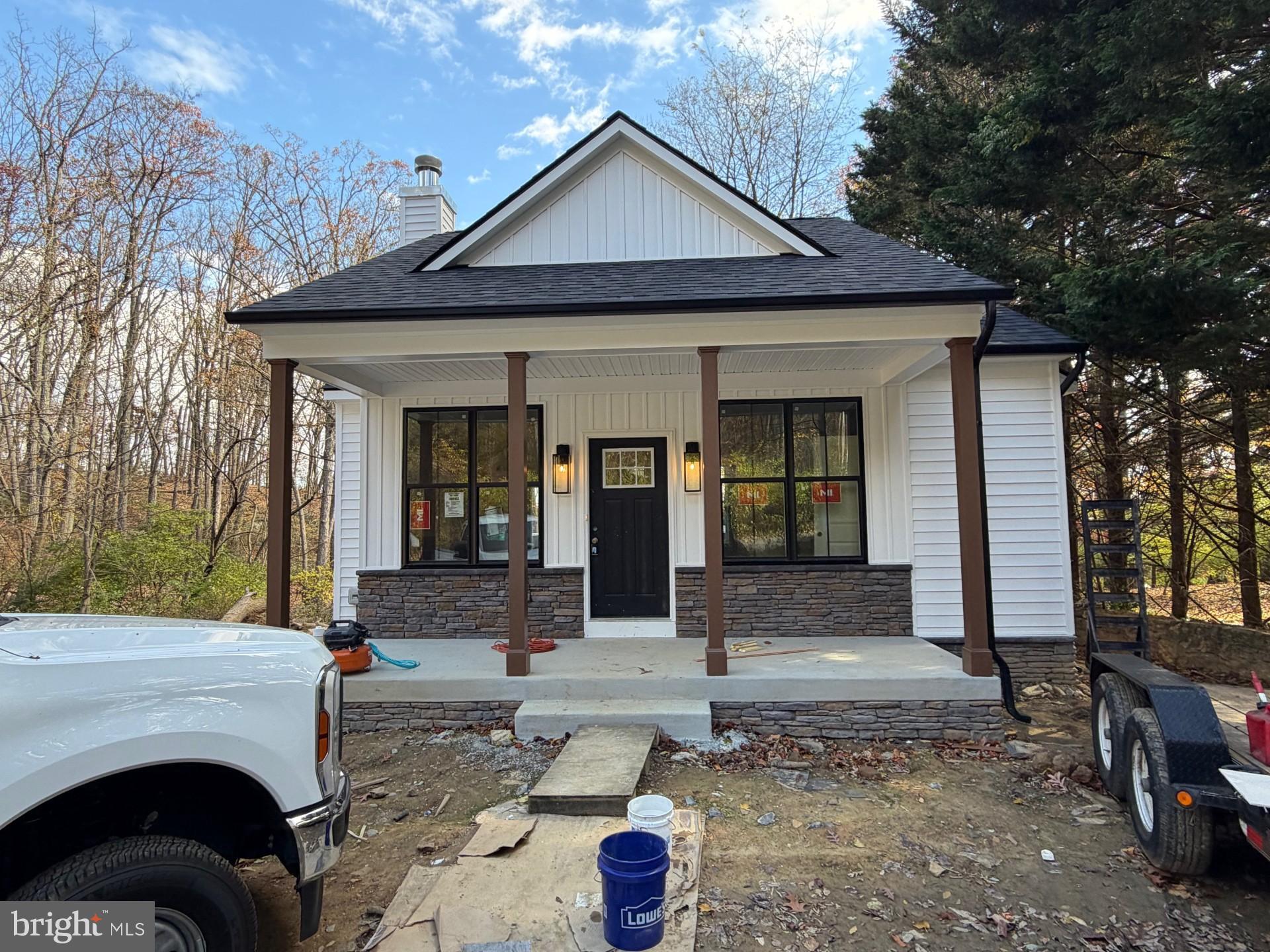 a front view of a house with barbeque and trees