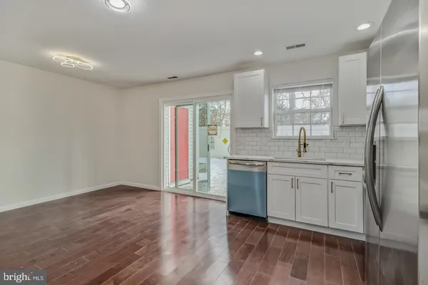 a kitchen with stainless steel appliances granite countertop a refrigerator and a sink