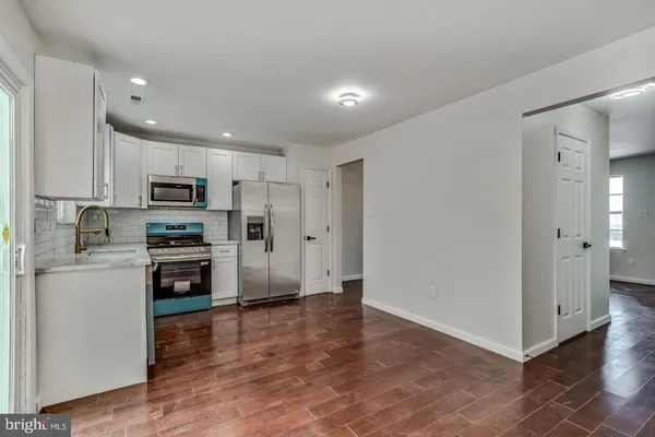 a kitchen with stainless steel appliances granite countertop a refrigerator and a stove top oven