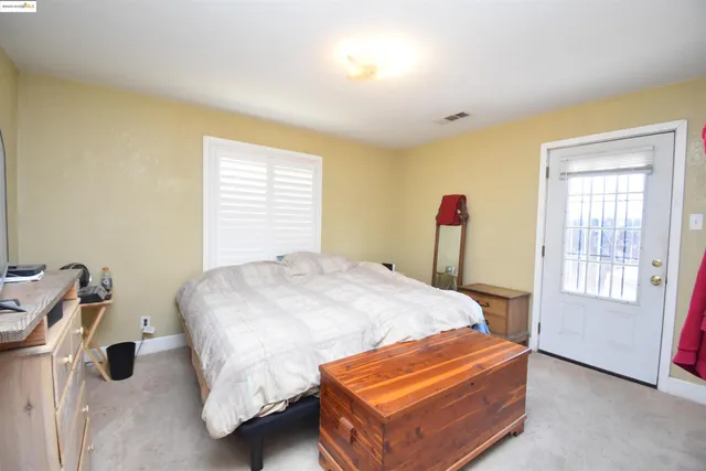 a bed sitting in a bedroom next to a window