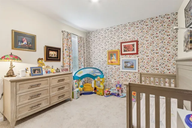 a view of a bedroom with baby crib and furniture